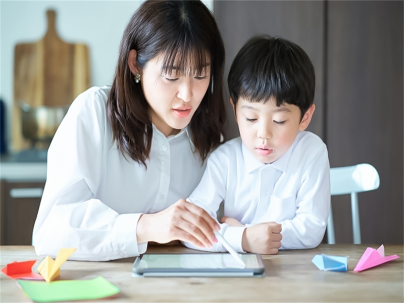 そろタッチをする子どもを真剣な表情で見守る親